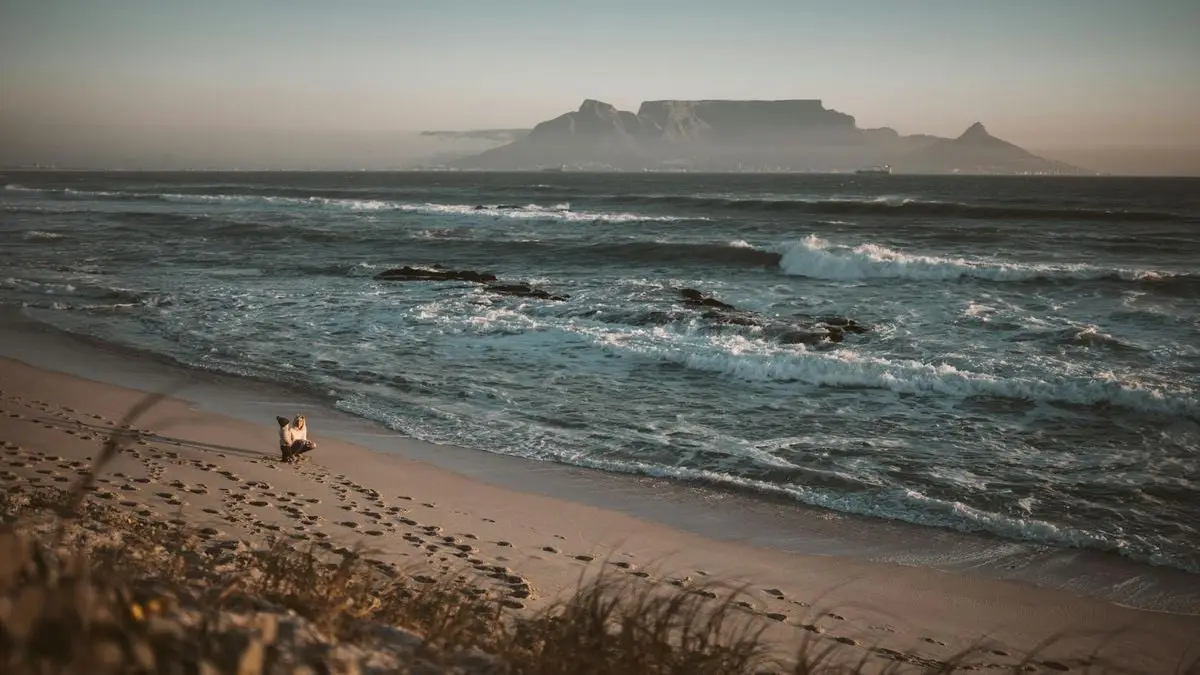 Captivating beach scene with Table Mountain in Cape Town, capturing a serene sunset.