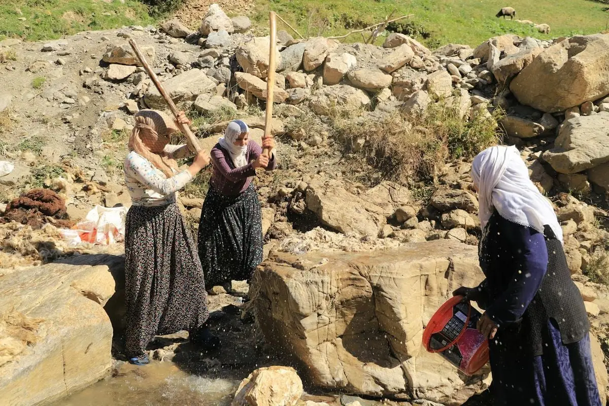 Traditional village women washing wool in Bahçesaray, Türkiye, depicting rural life.