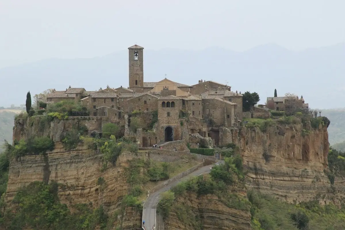 Ancient hilltop village Civita di Bagnoregio in Italy, surrounded by lush landscape.