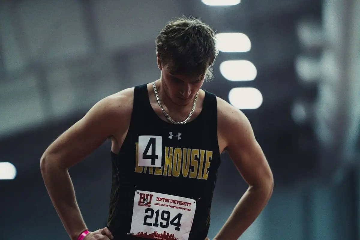 Athlete in sportswear focusing before competition at Boston University track event.