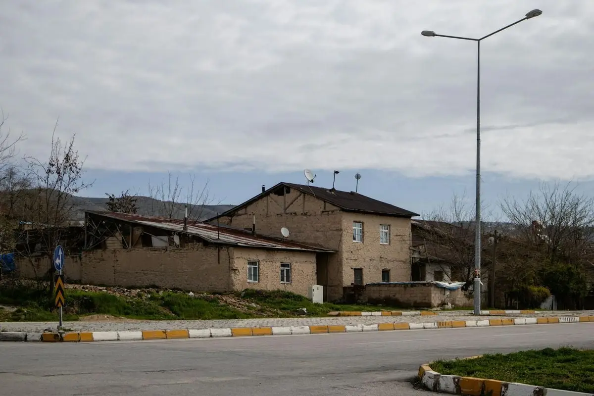 A quiet street with old buildings in Elâzığ, Türkiye. Captured on a cloudy day, showcasing rustic architecture.