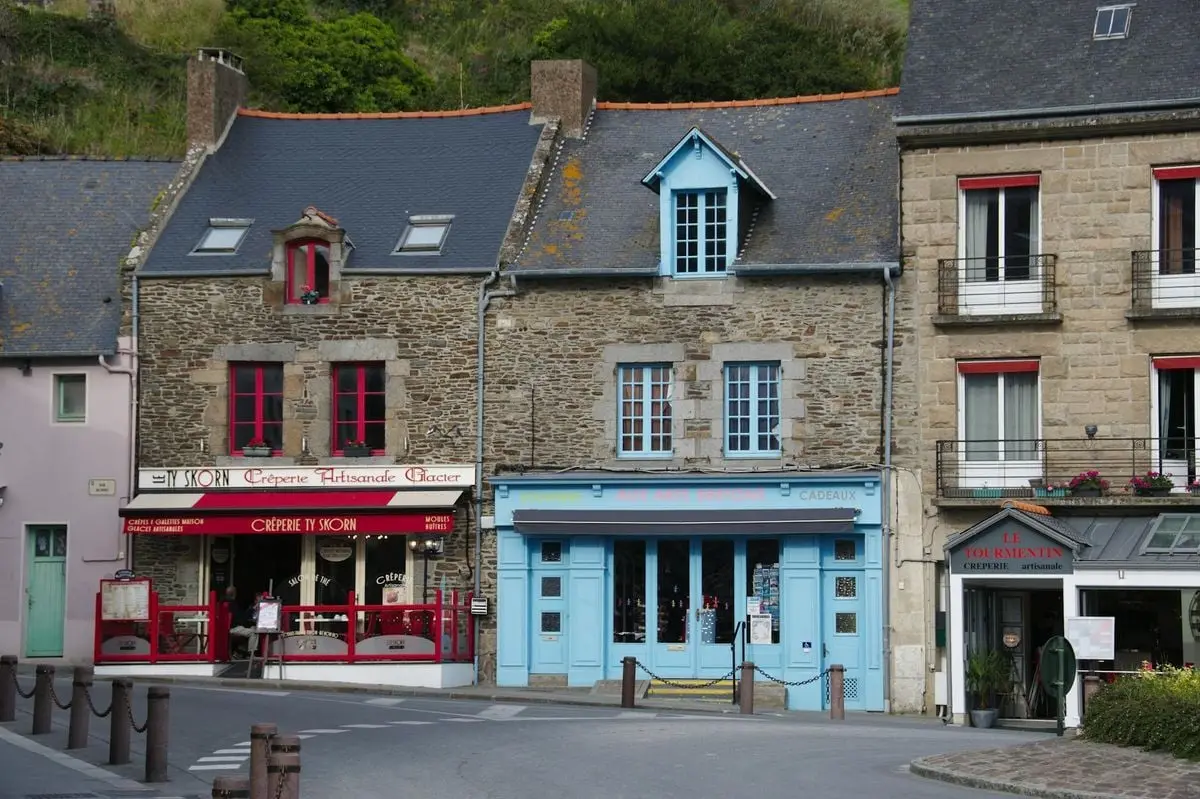 Colorful buildings along a traditional street in Cancale, France, showcasing Breton architecture.