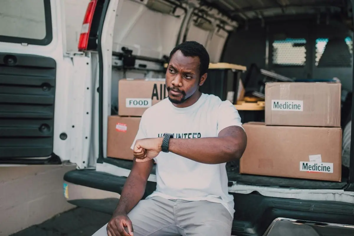 A volunteer organizing aid deliveries including food and medicine from a van.