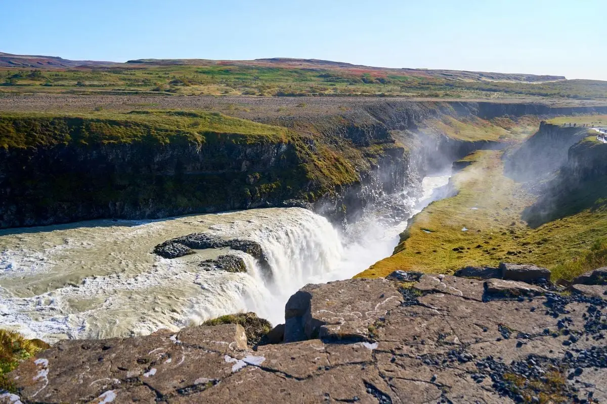 Capture of Gullfoss waterfall cascading into a canyon in Iceland under clear skies.