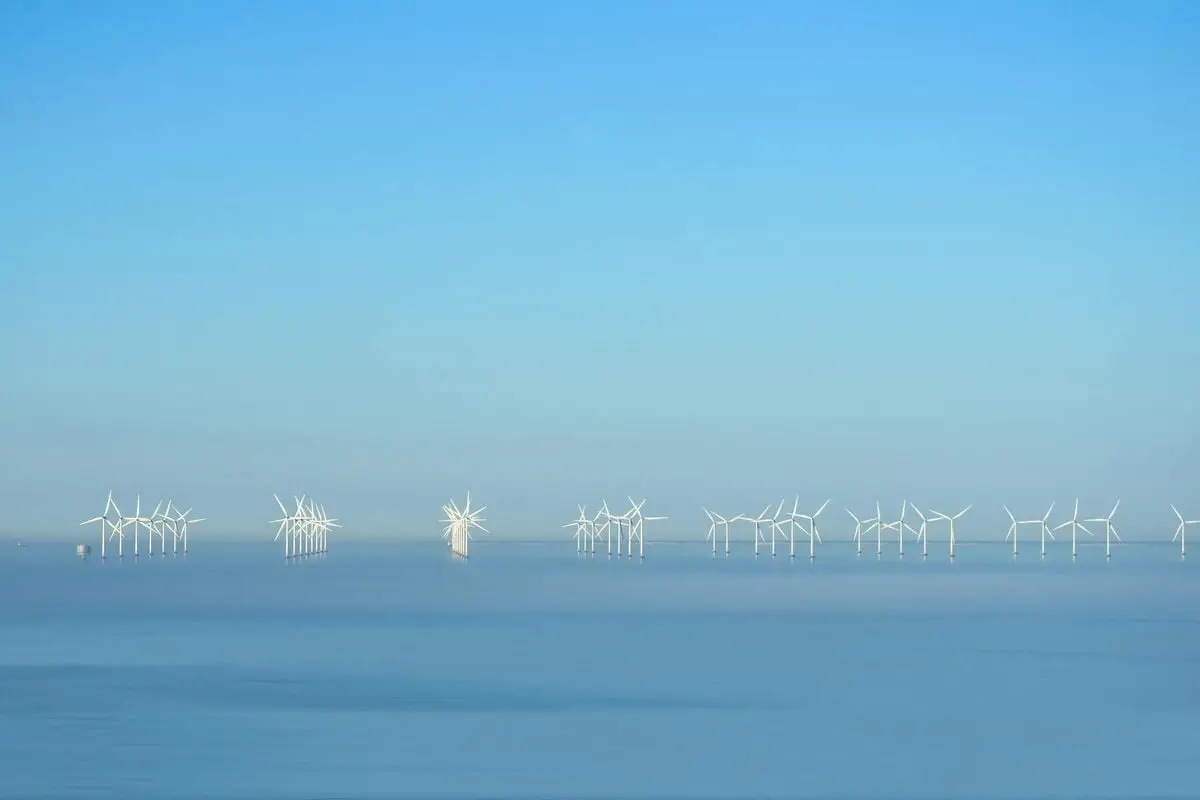 Serene offshore wind turbines beneath a clear blue sky generating renewable energy.
