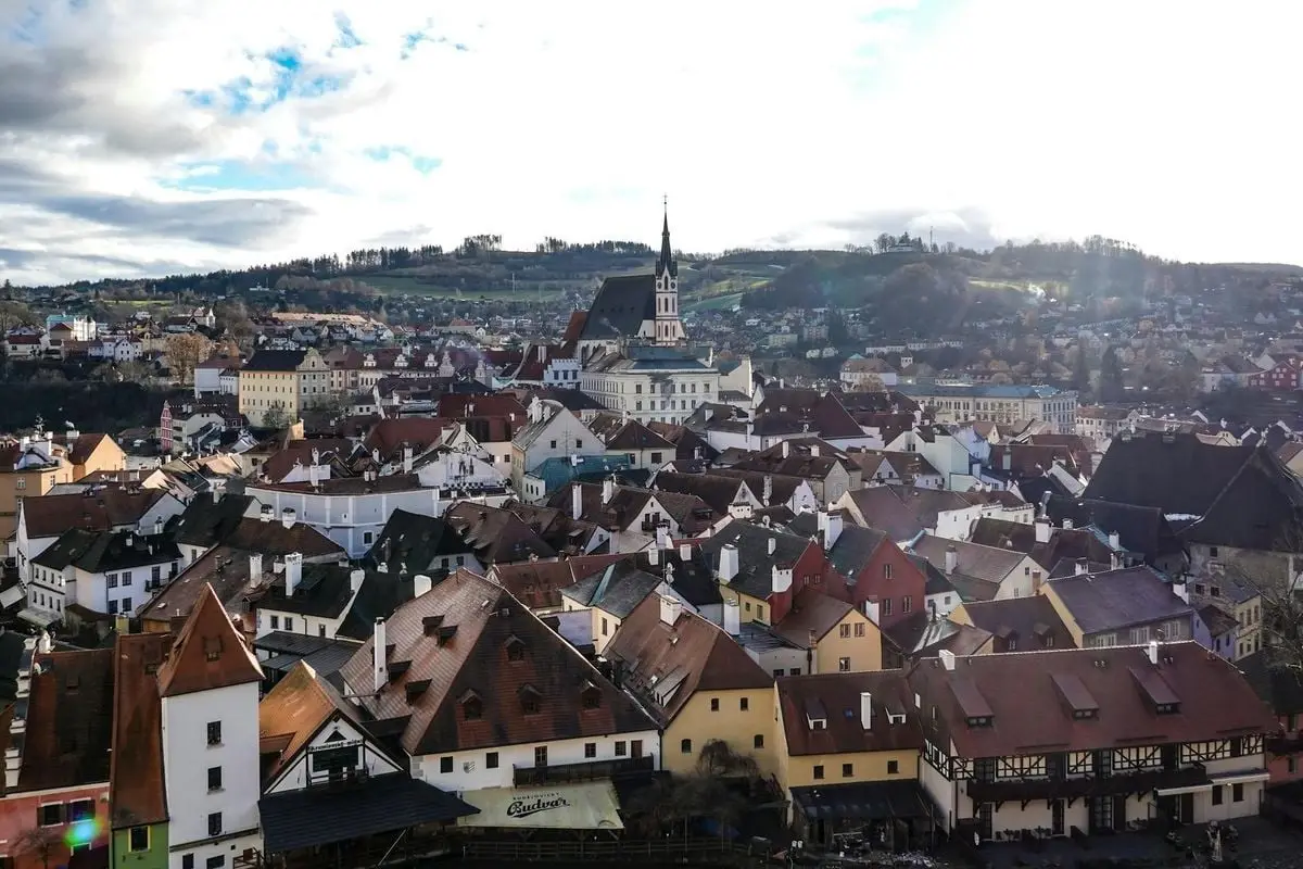 Aerial view of Český Krumlov's charming old town with historic rooftops and church spire.