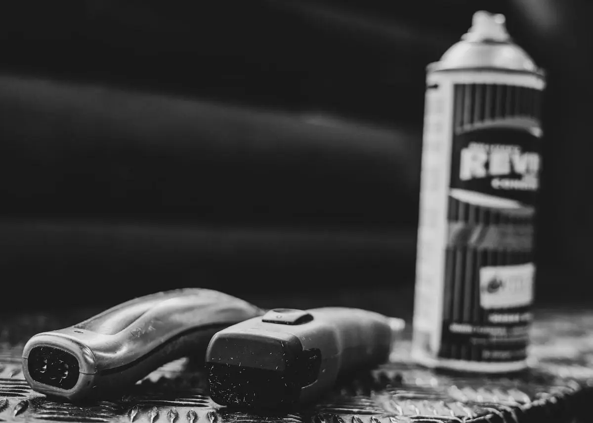 A black and white image of a spray can and tools on a textured surface, conveying safety and industrial themes.