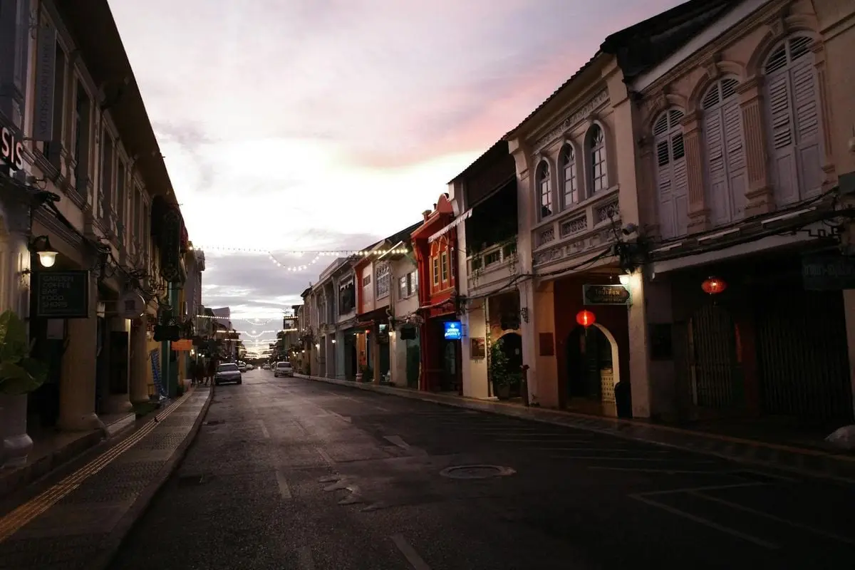 Charming colonial street in Phuket Town at dusk with vibrant architecture and atmospheric lighting.