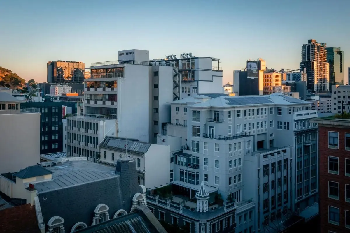 A stunning view of Cape Town's cityscape at sunset, showcasing modern and historic architecture.