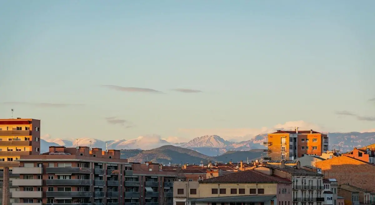Aerial city view of Manresa with mountain backdrop during daytime.