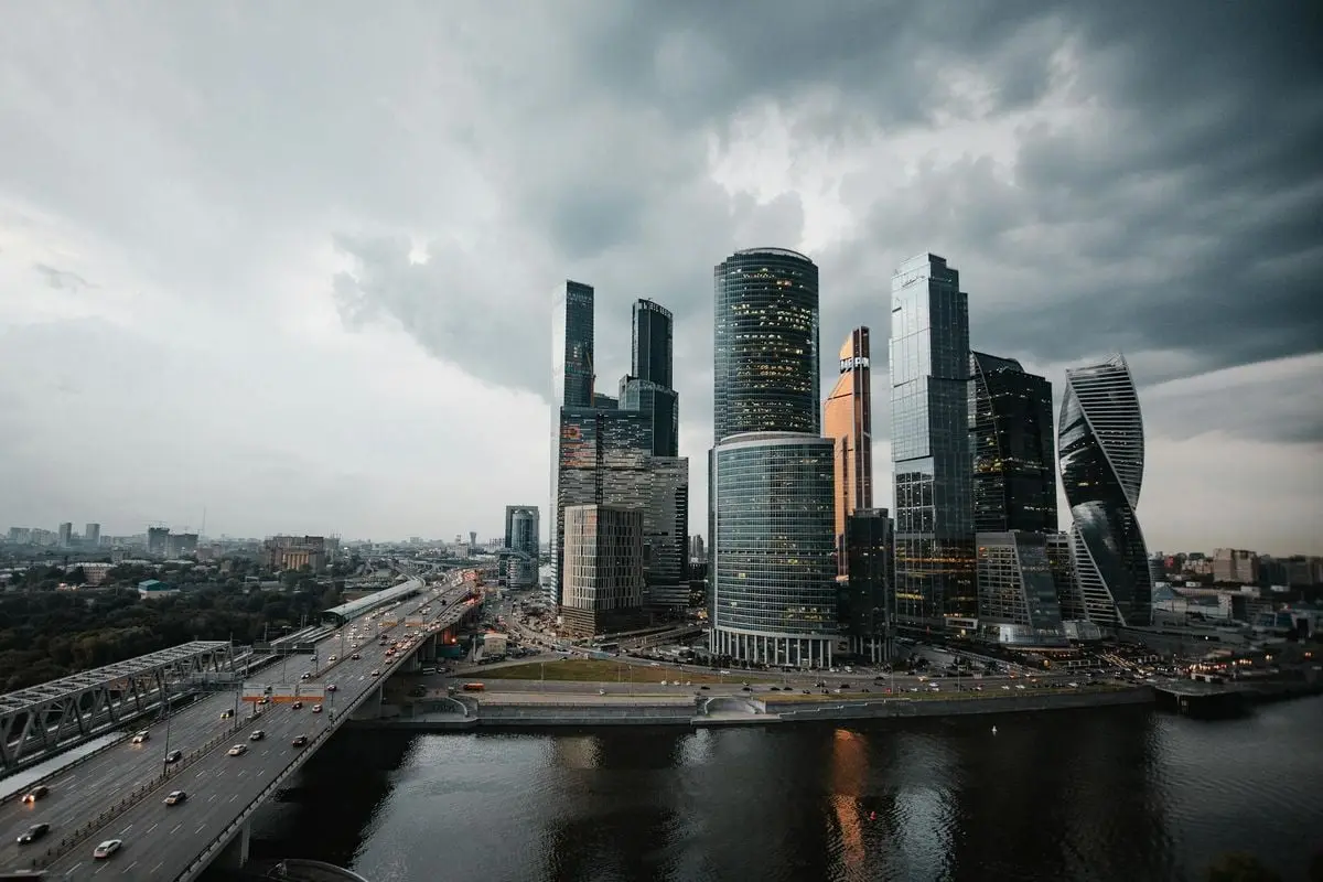 A dramatic view of Moscow's skyscrapers under a cloudy sky, reflecting modern architecture.