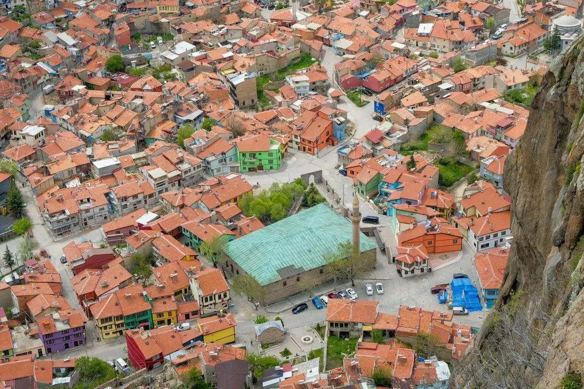 Stunning aerial view of a vibrant town with terracotta roofs and colorful buildings, showcasing urban architecture.