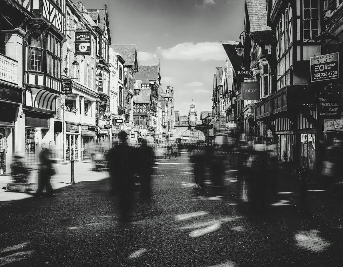 Dynamic black and white city scene capturing Chester's iconic architecture and bustling streets.