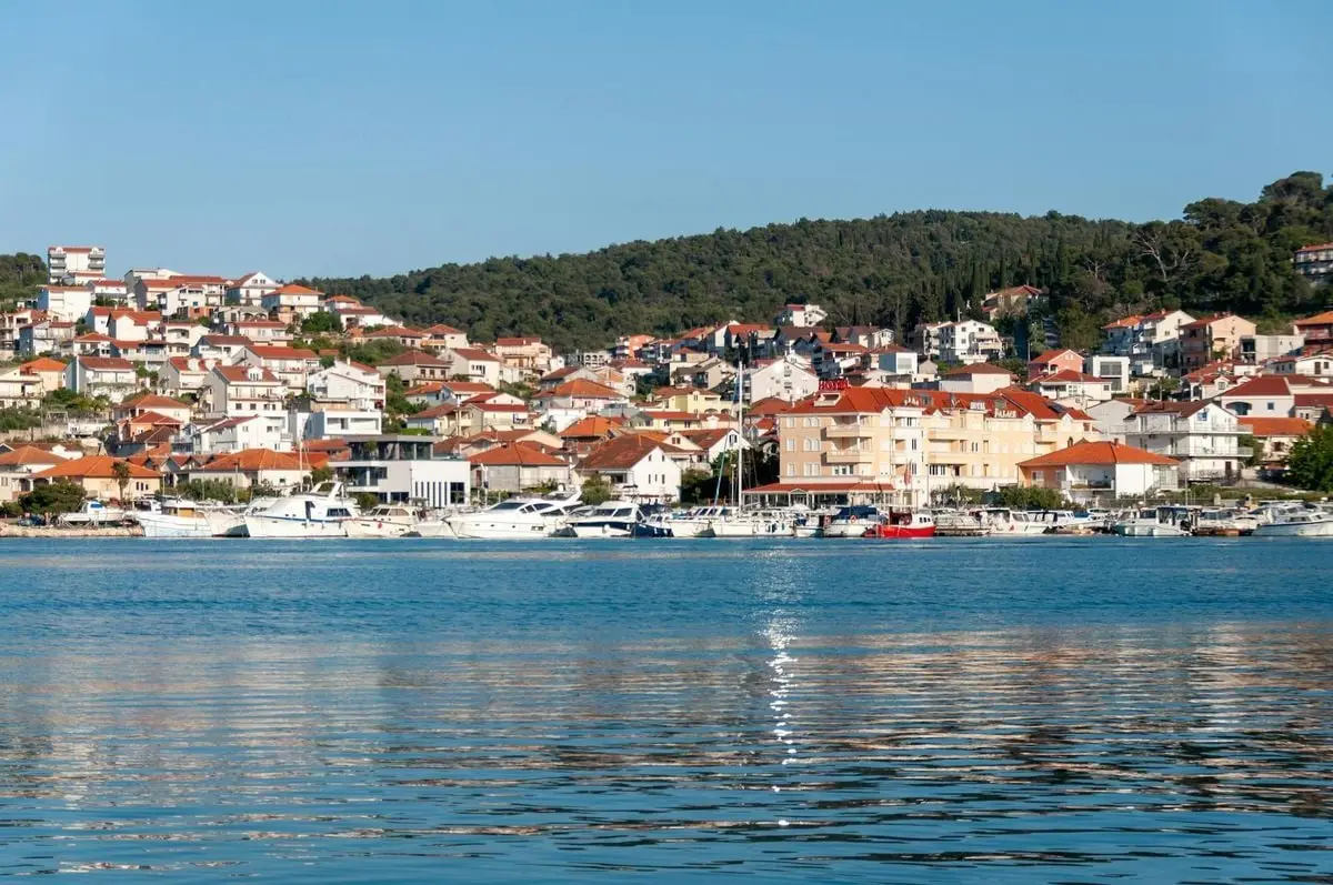 Beautiful view of Trogir's vibrant waterfront with boats and hillside houses.