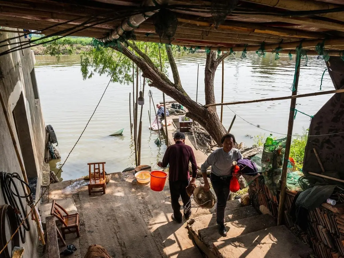An authentic scene of rural life with fishermen at a river jetty, capturing daily activities.