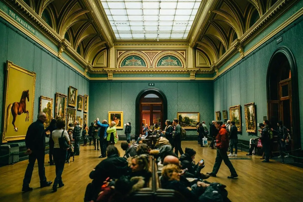 A bustling art gallery with people admiring paintings and architectural details.