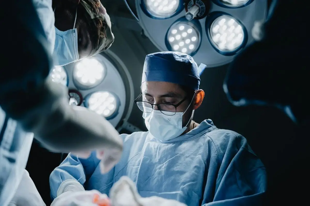 Surgeons performing a medical procedure in a well-lit, modern operating room in Mexico.