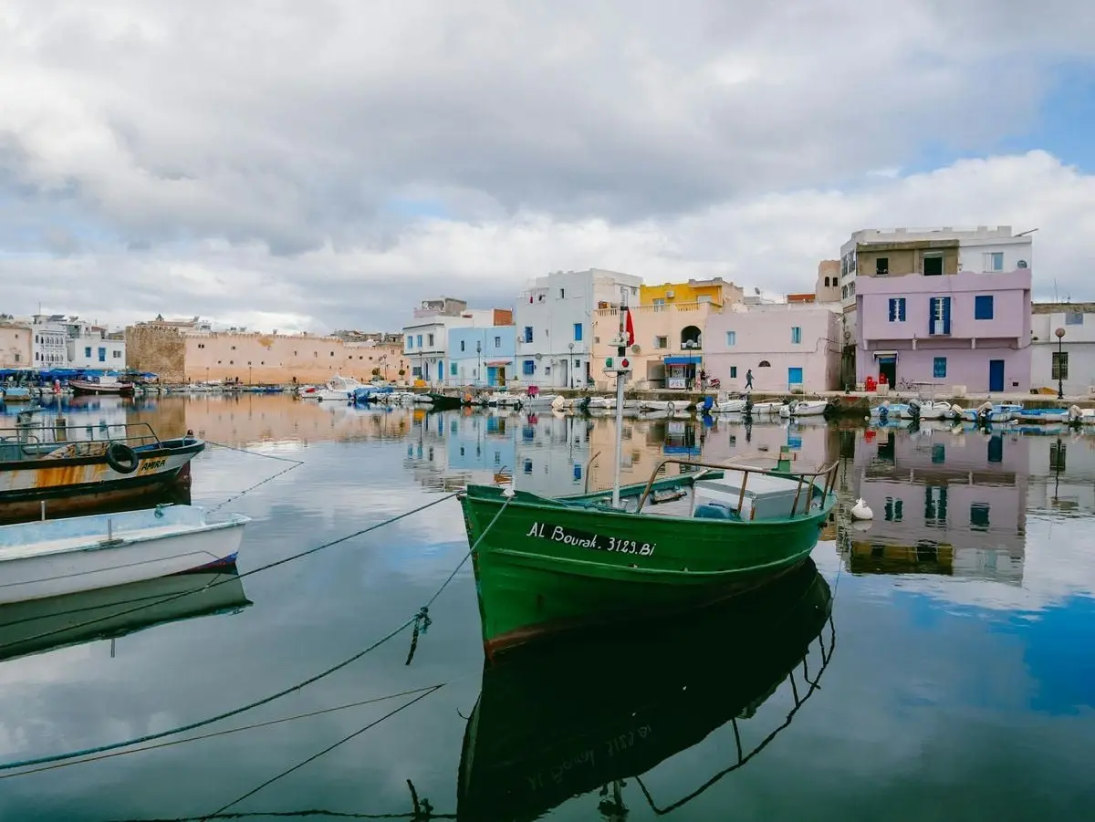 A tranquil harbor with colorful buildings reflecting in the water.
