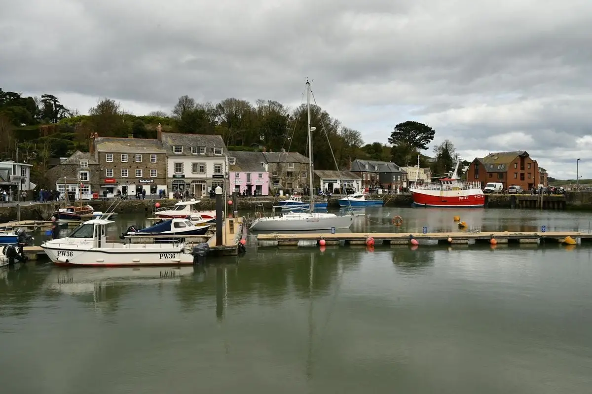 Serene view of a coastal harbor with boats docked, surrounded by charming buildings.
