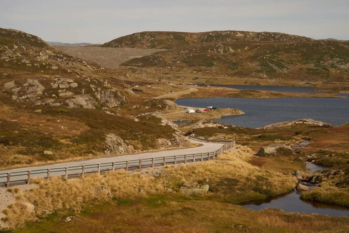 Explore the tranquil beauty of Agder, Norway, with a scenic road winding through mesmerizing highlands and water bodies.