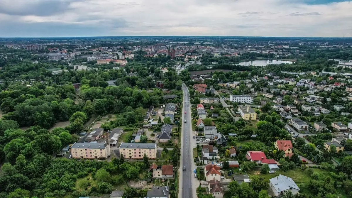 Aerial shot of a vibrant town with greenery, roads, and buildings offering a peaceful urban landscape.