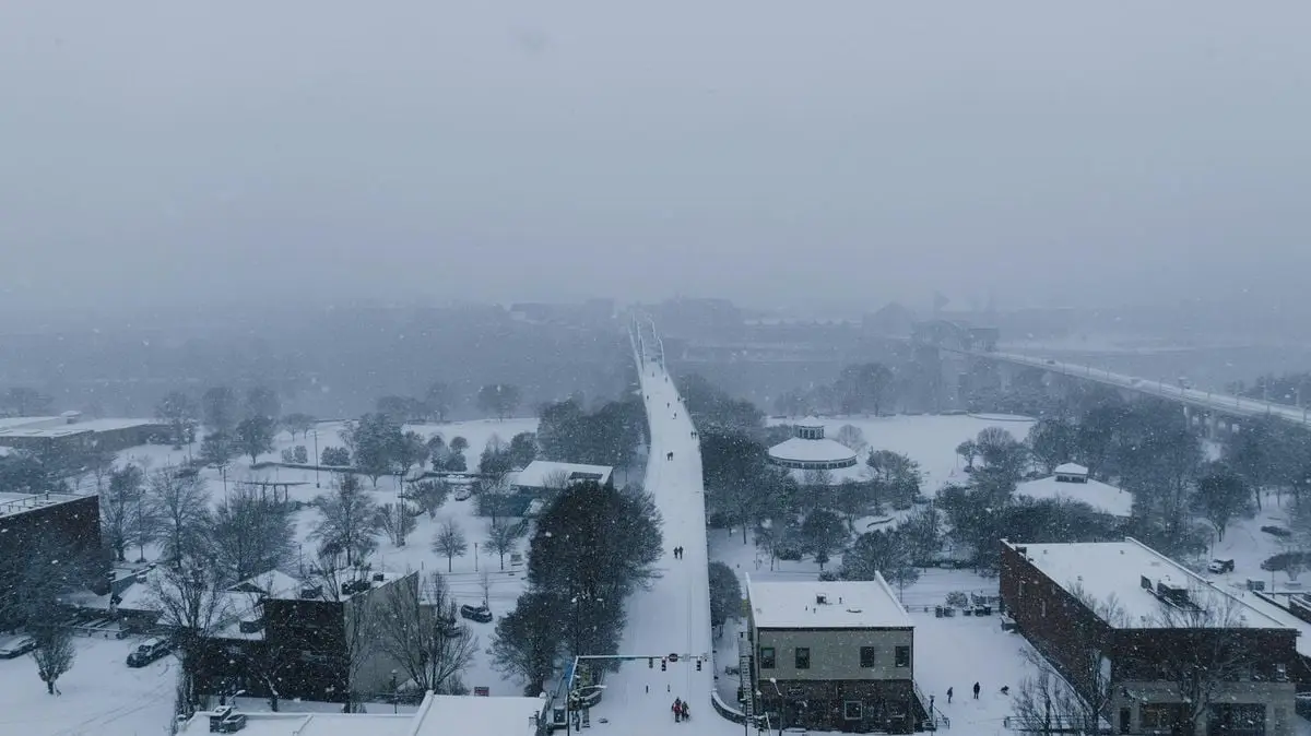 Aerial view of Chattanooga under a snowy winter, showcasing frozen roads and snow-covered rooftops.