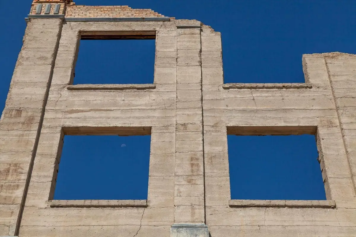 Historic building facade in Rhyolite ghost town, Nevada under a clear blue sky.