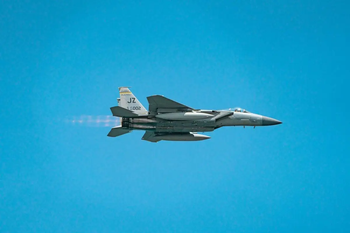 A military jet soaring through a clear blue sky, showcasing speed and precision.