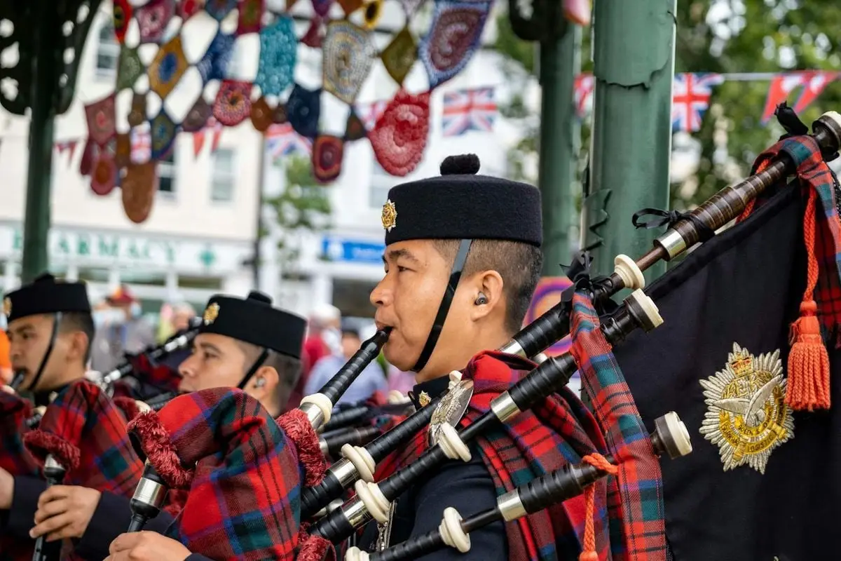 Gurkha soldiers performing in a pipe band in Aldershot, England, during a festive celebration.