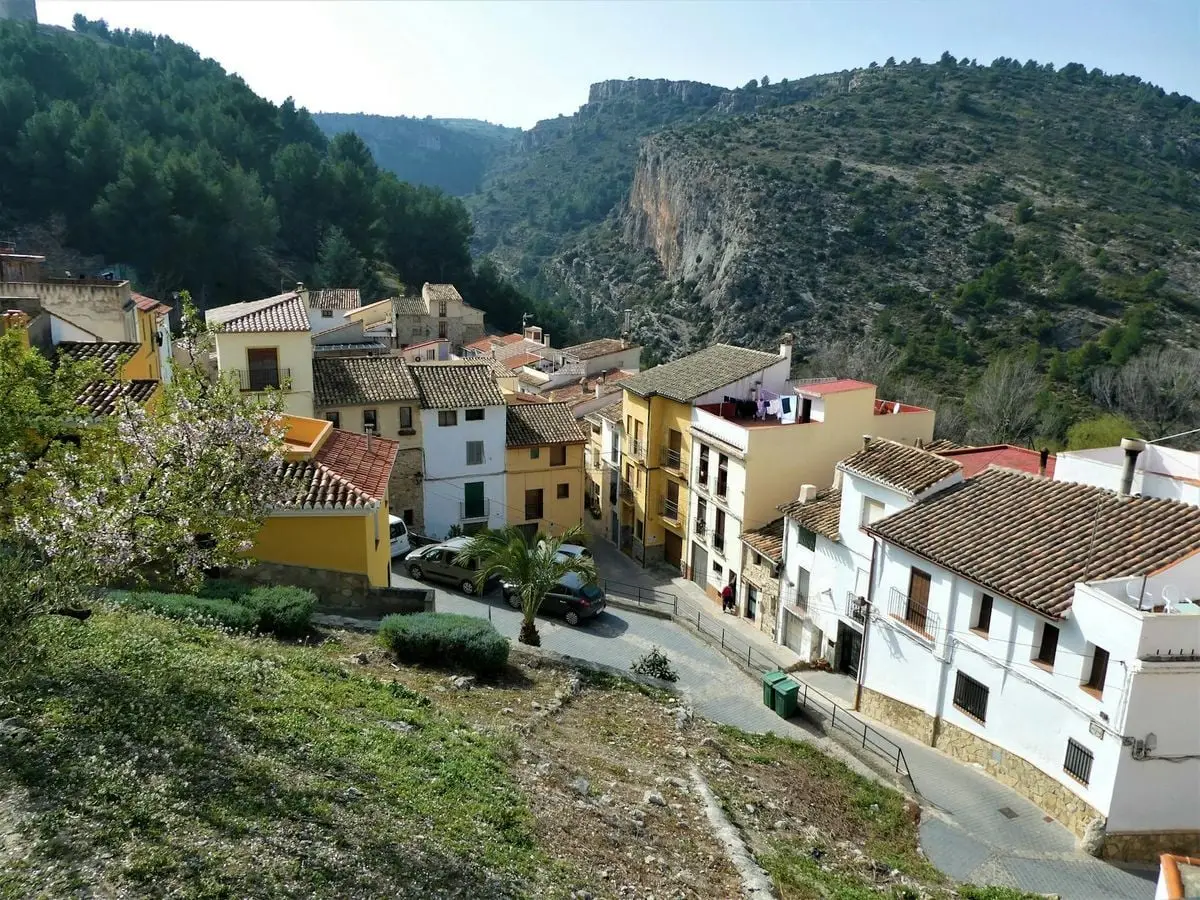 Beautiful view of Xèrica in Spain, showcasing colorful houses and mountainous terrain under a clear sky.