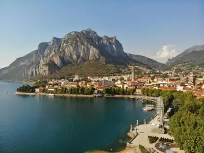 Aerial view of Lecco, Italy with towering mountains and serene waters.