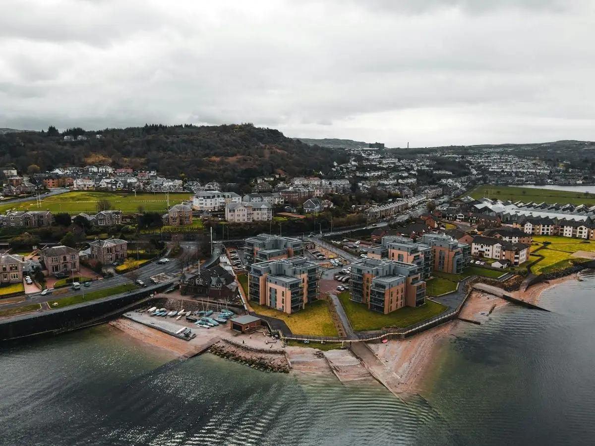 Aerial view of a coastal town in Scotland showing buildings and sea shore.
