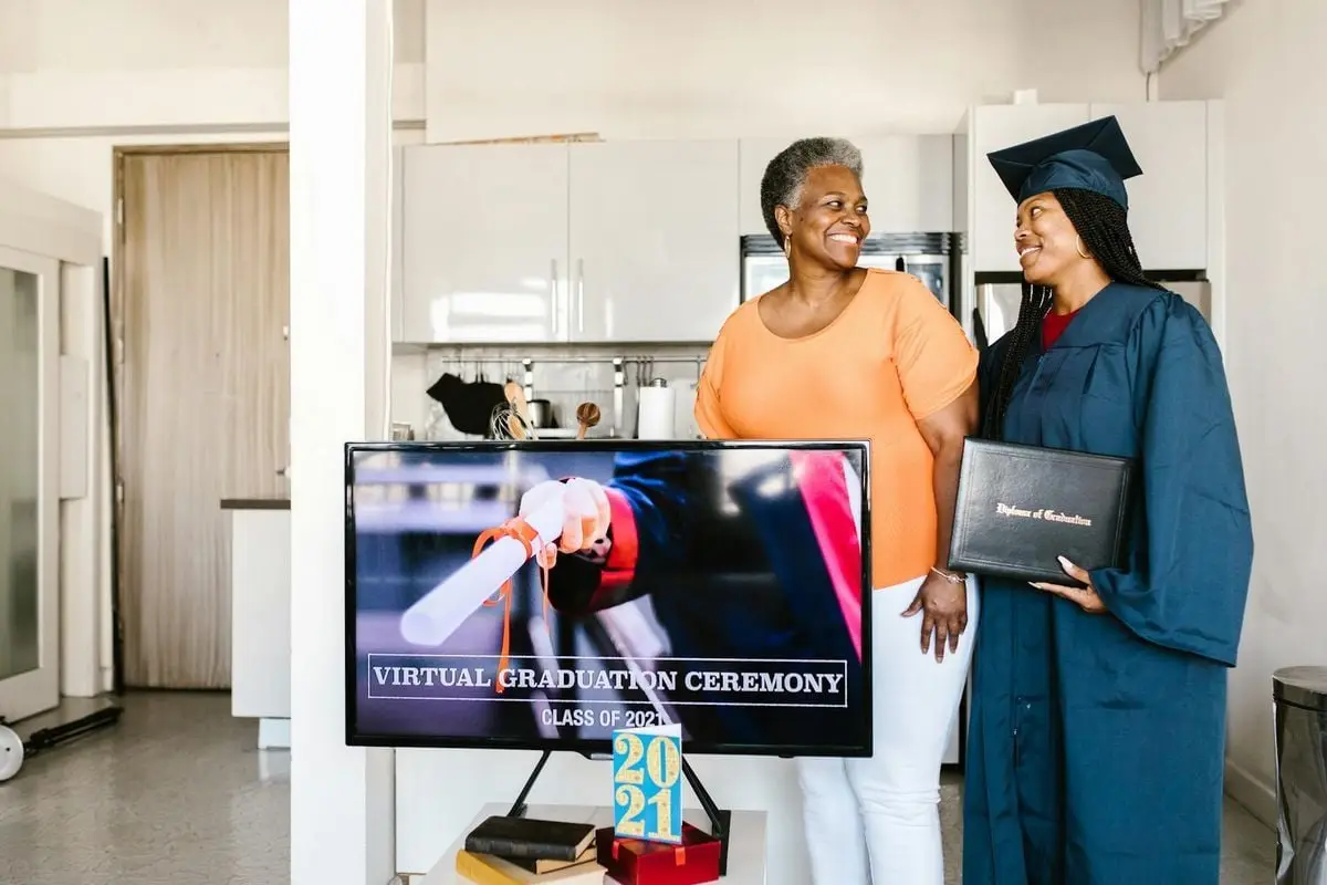 Smiling family at home celebrating virtual graduation with 2021 diploma.
