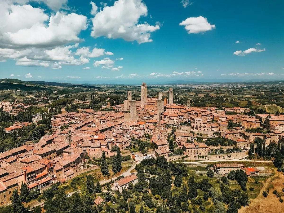 Breathtaking aerial view of the medieval town of San Gimignano in Tuscany, Italy, showcasing iconic towers and scenic landscapes.