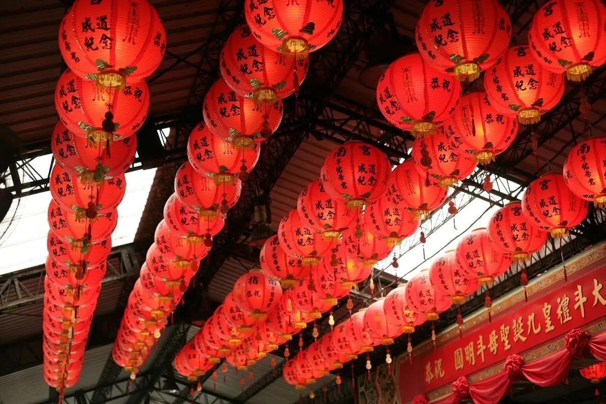 Red Chinese lanterns with calligraphy hanging indoors, creating a festive atmosphere.