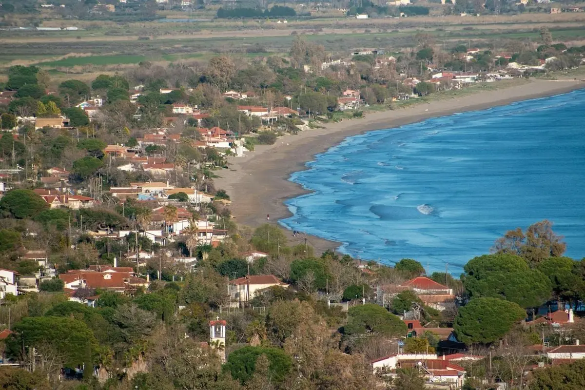 A stunning aerial view of the coastal town of Katakolo, Greece, featuring lush greenery and sandy beaches.