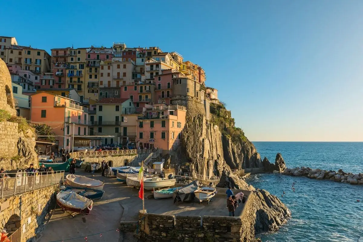 Colorful houses and boats in Manarola, Liguria, Italy captured at sunset.