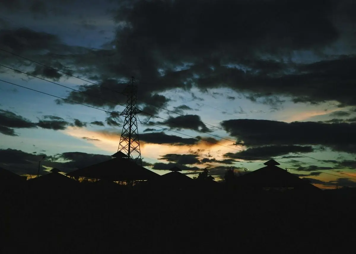 Dramatic twilight sky with silhouettes of electric post and rooftops in Cota, Colombia.