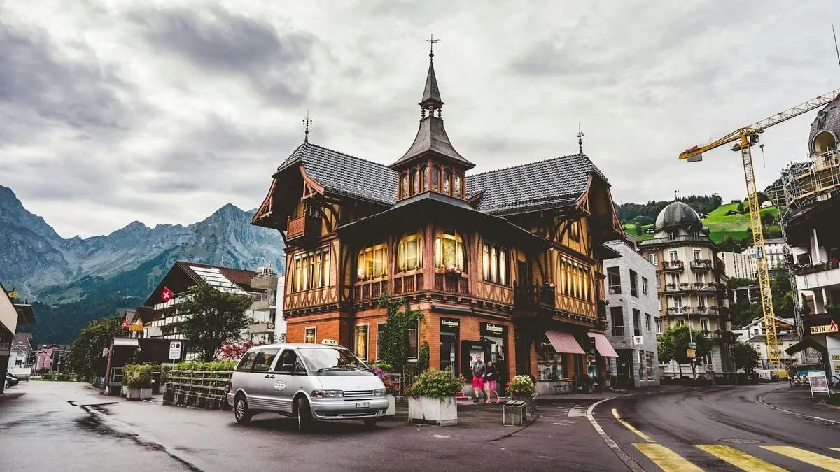 Explore the picturesque charm of a Swiss town with stunning traditional architecture set against a mountainous backdrop.