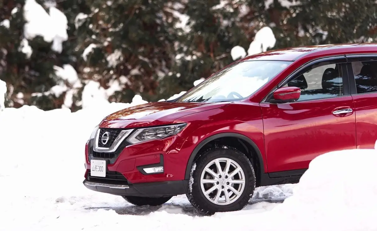 A red SUV parked on a snow-covered landscape during winter.