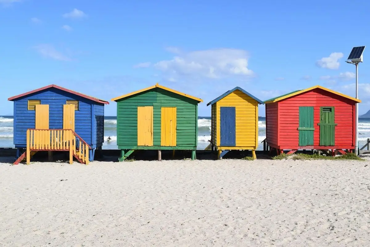 Vibrant beach huts on Muizenberg Beach, Cape Town, perfect for a summer travel escape.
