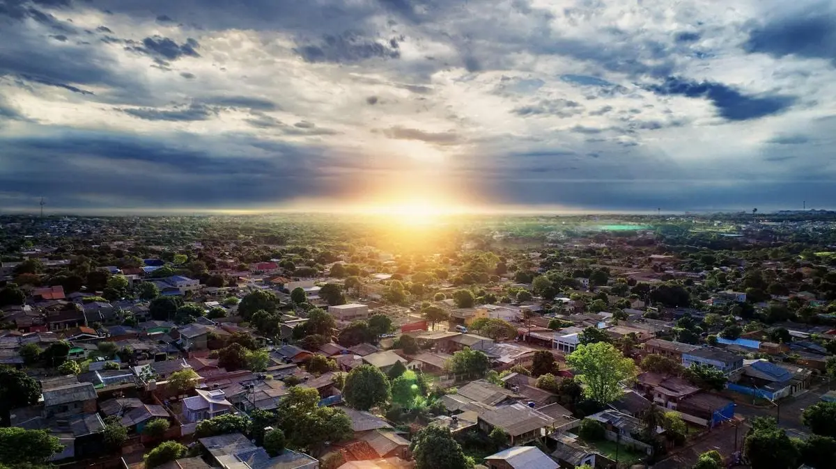 Beautiful aerial shot capturing a village with houses and trees during sunrise.