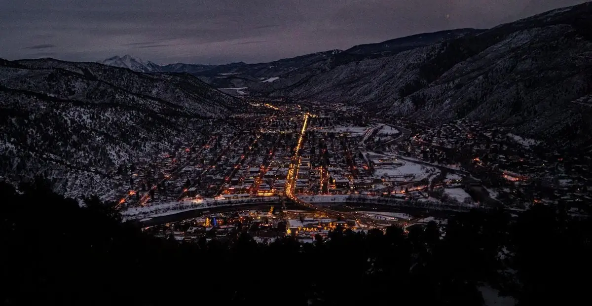 Captivating aerial night view of Glenwood Springs, CO in winter, highlighting urban lights.