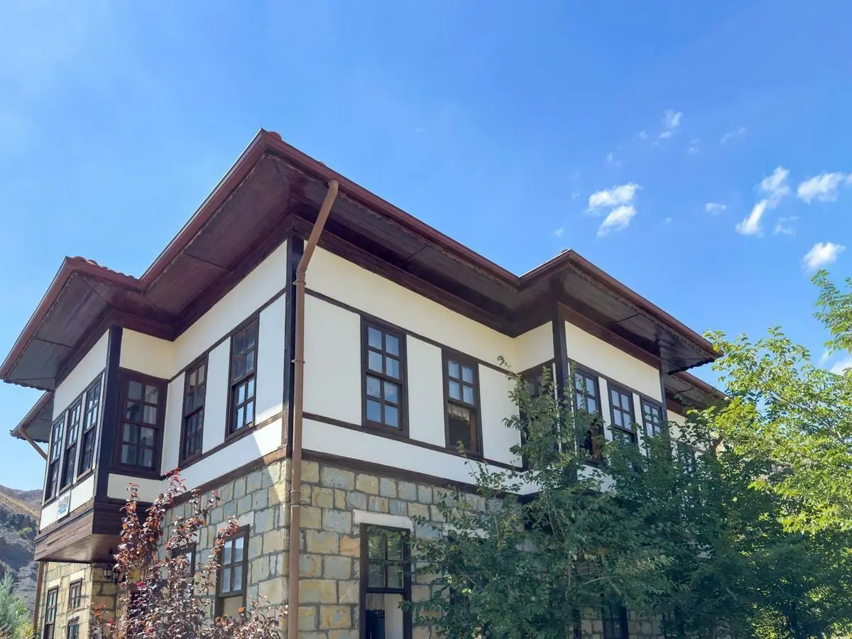 Charming traditional Turkish house with wooden beams in Elazığ, Türkiye, under a clear blue sky.