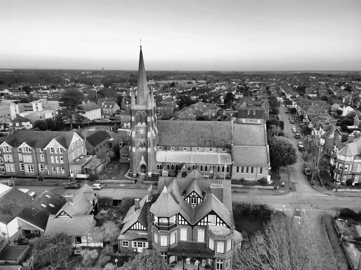 Black and white aerial view of a historic town with a prominent church spire and classic architecture.
