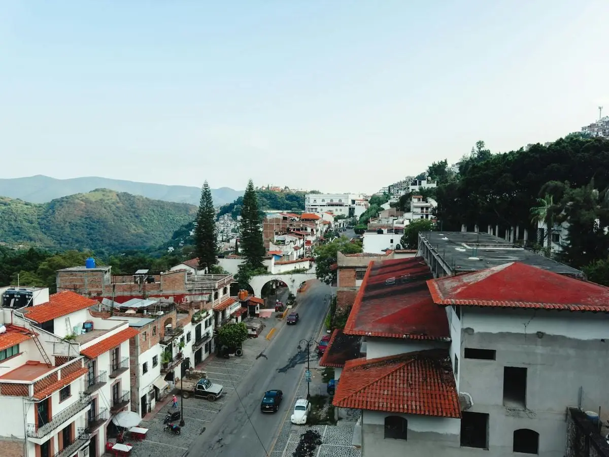 Aerial view of charming Taxco, Guerrero with red roofs and lush hills.