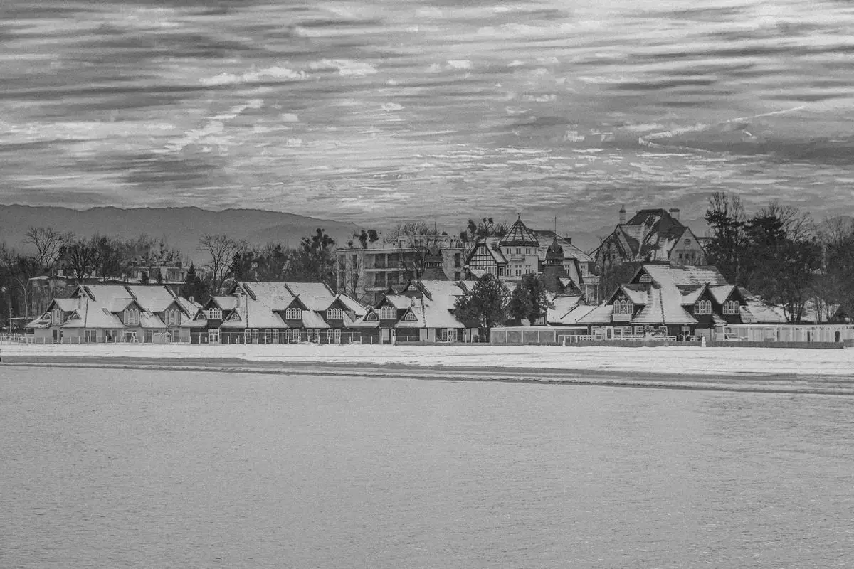A monochrome photo capturing the snowy skyline of Sopot, Poland, showcasing traditional architecture.