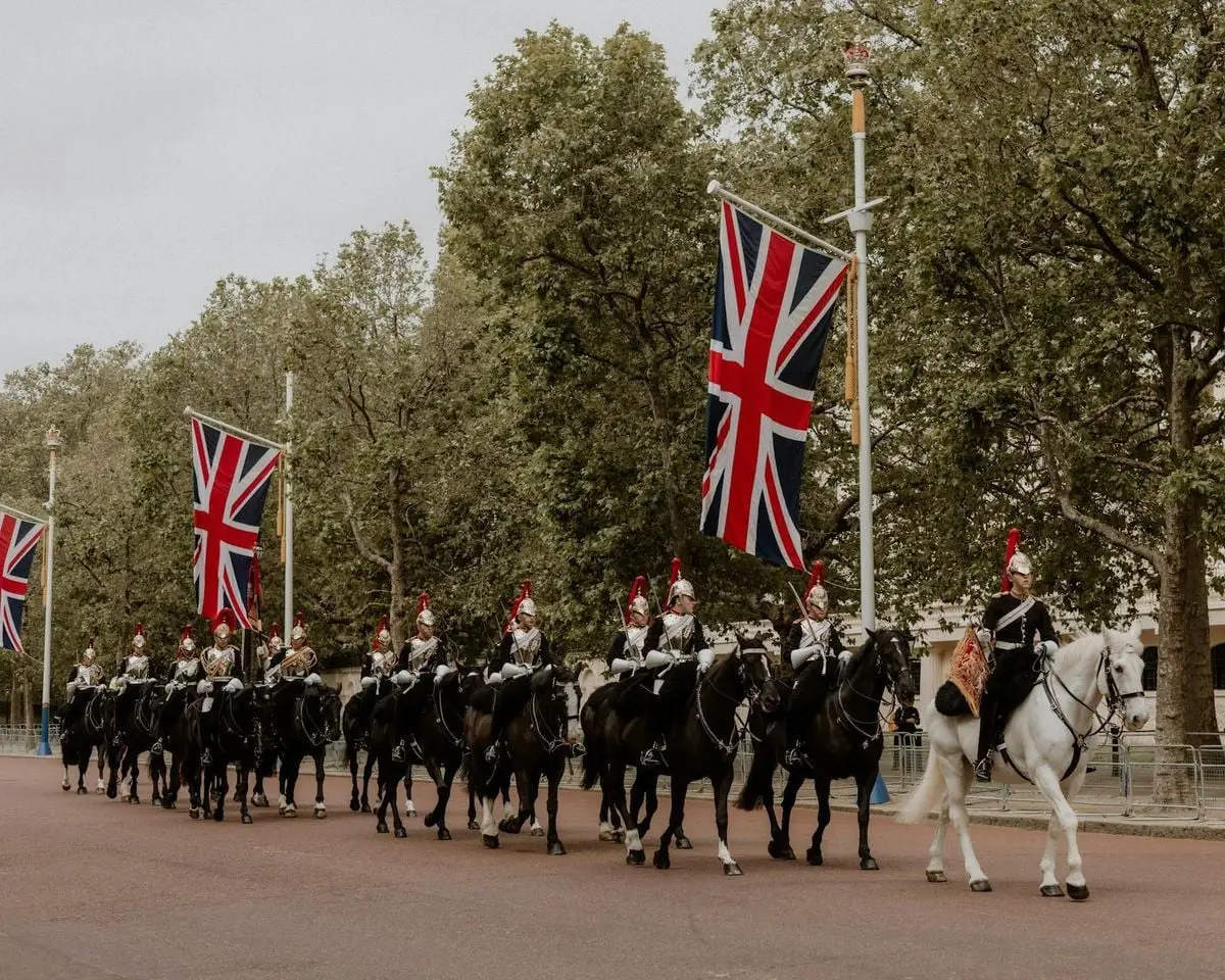 Ceremonial cavalry with Union Flags in a historical parade on The Mall, London.
