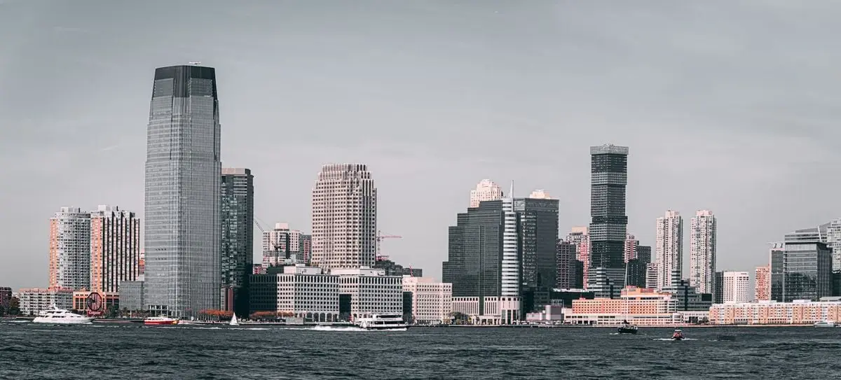 A breathtaking view of Jersey City's skyline from across the Hudson River with modern skyscrapers and waterfront buildings.
