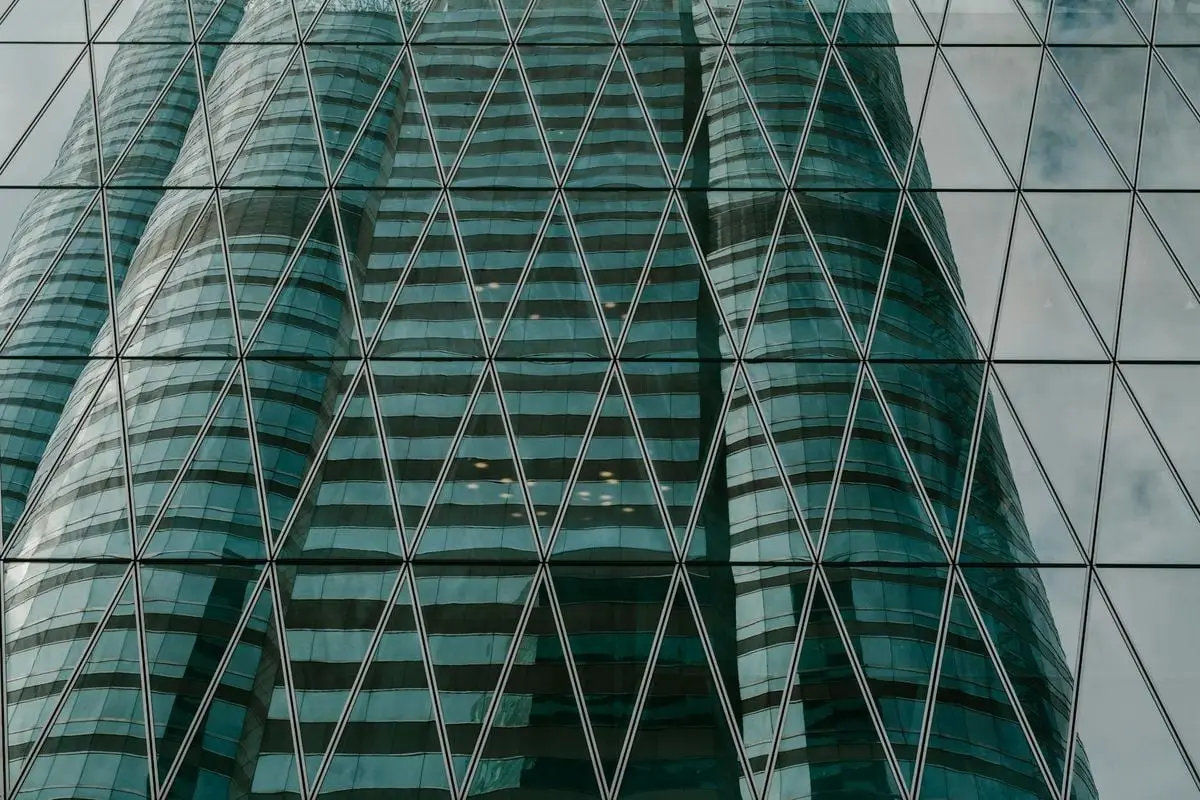 Reflection of modern skyscraper in glass façade, showcasing urban architecture